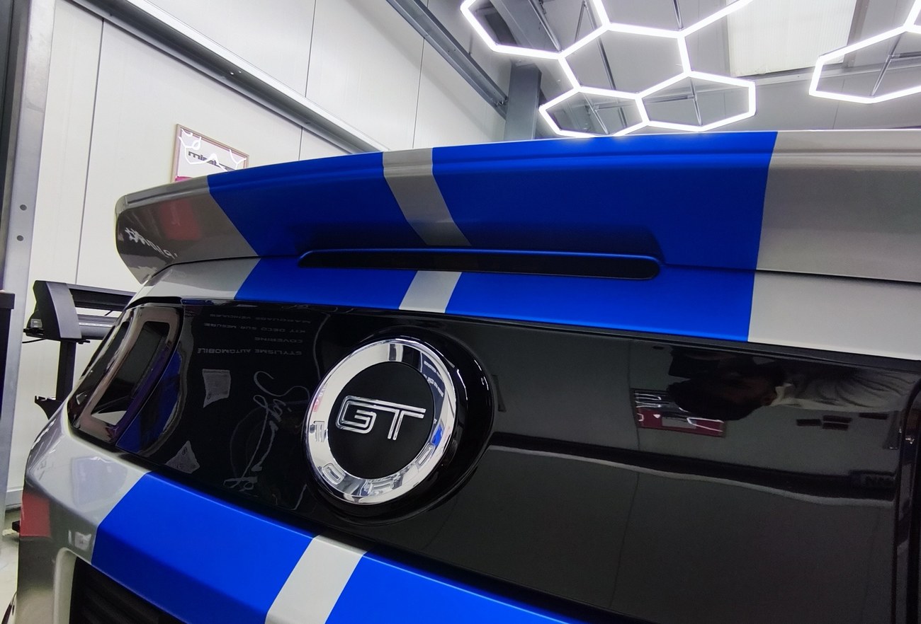 Ford Mustang bandes bleu et blanc — détail becquet et badge GT