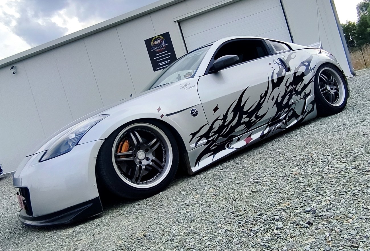 Nissan 350Z flammes tribales — vue trois-quarts avant devant l'atelier
