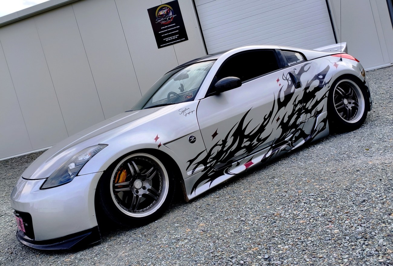 Nissan 350Z flammes tribales — vue latérale complète devant l'atelier