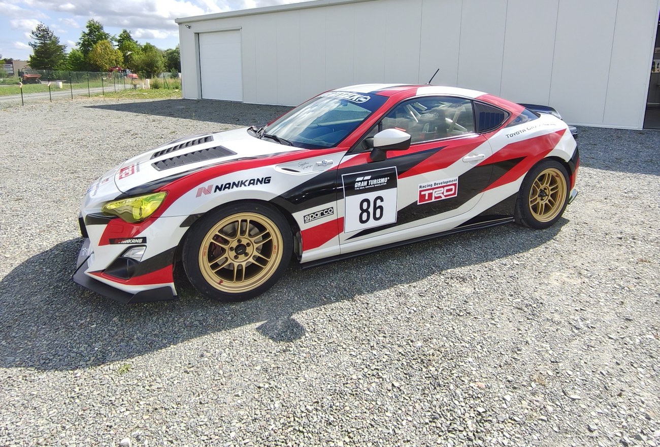 Toyota GT86 livrée Time Attack — vue avant ¾ devant l'atelier